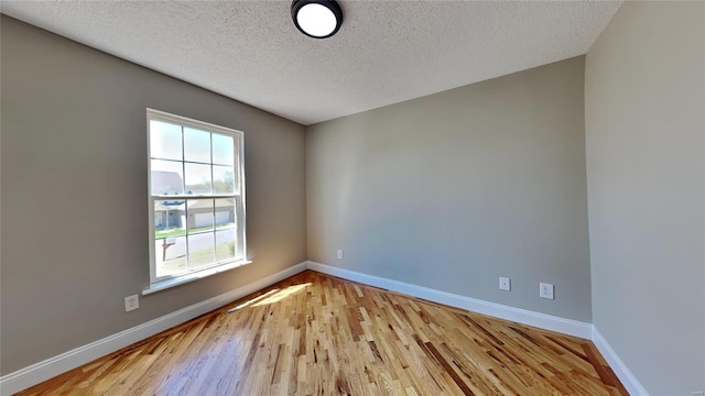 empty room featuring light hardwood / wood-style floors and a textured ceiling