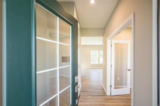 hallway with french doors and light hardwood / wood-style floors