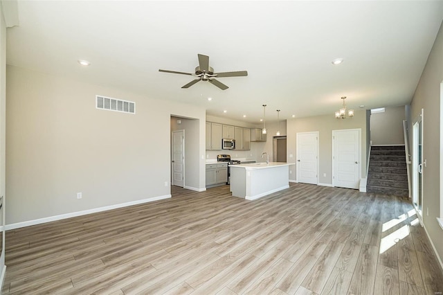 unfurnished living room with sink, ceiling fan with notable chandelier, and light hardwood / wood-style flooring