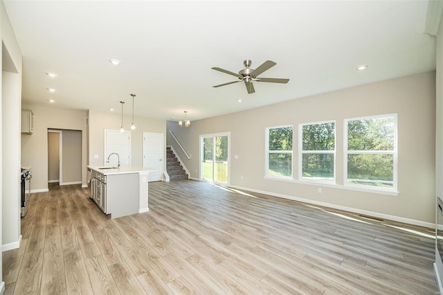 unfurnished living room featuring ceiling fan, sink, and light hardwood / wood-style flooring