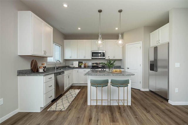 kitchen featuring white cabinetry, a center island, sink, and appliances with stainless steel finishes