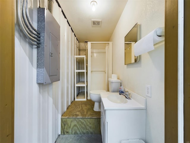 bathroom with toilet and vanity with extensive cabinet space