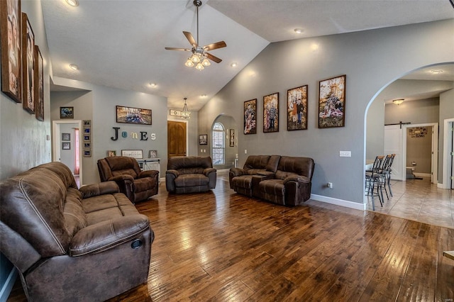 living room with vaulted ceiling, a barn door, ceiling fan, and hardwood / wood-style floors