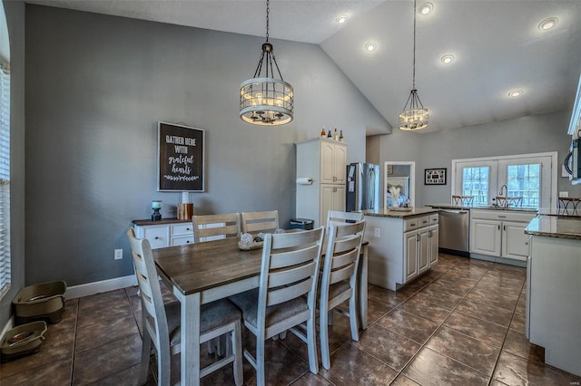 dining area featuring french doors, dark tile flooring, high vaulted ceiling, and sink