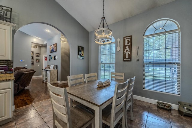 tiled dining room with lofted ceiling