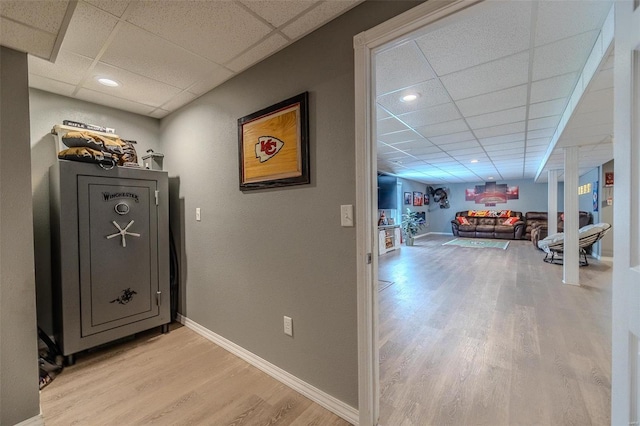 hallway featuring light hardwood / wood-style floors and a paneled ceiling