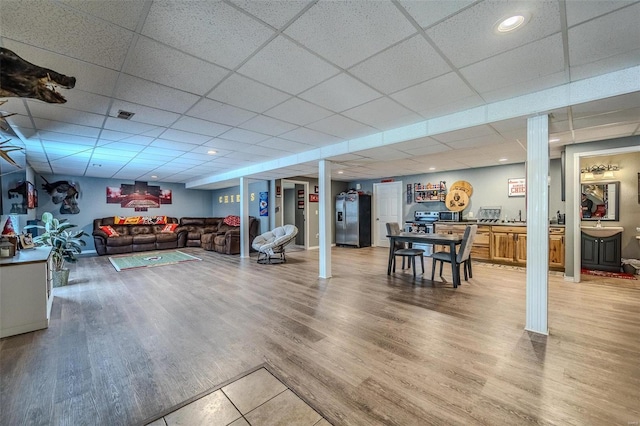 interior space with a drop ceiling and hardwood / wood-style floors