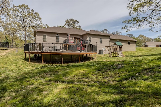 back of property with central AC unit, a wooden deck, and a lawn