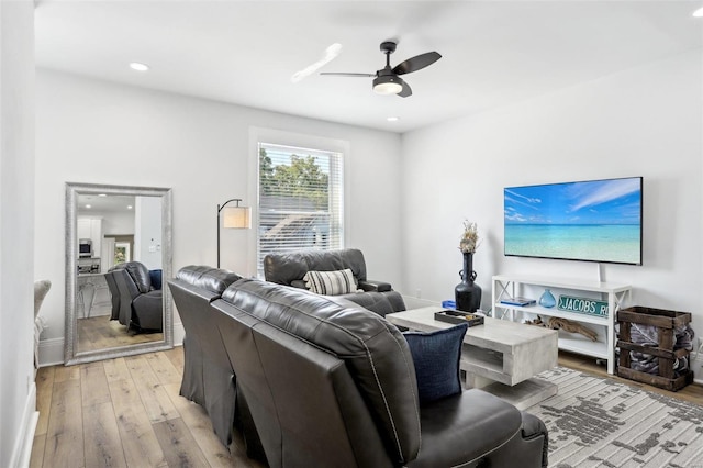 living room with light wood-type flooring and ceiling fan