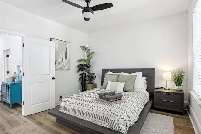 bedroom with ceiling fan, light hardwood / wood-style flooring, and multiple windows