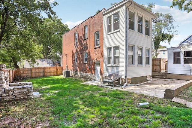 back of house featuring a lawn, a patio, and central air condition unit