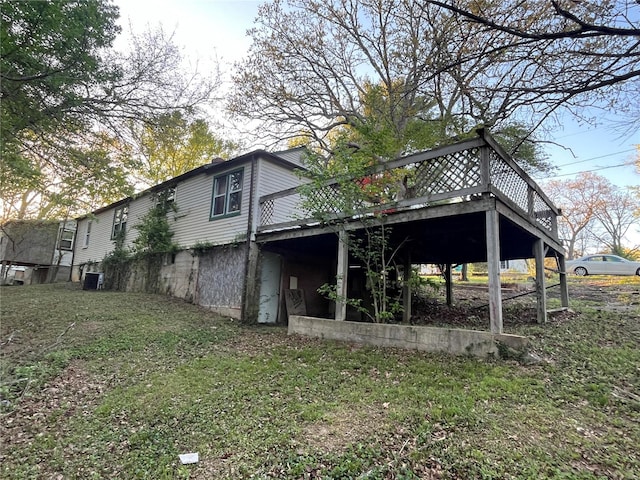 back of property with a wooden deck and a lawn