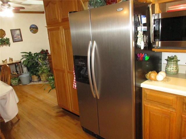 kitchen with light hardwood / wood-style flooring, stainless steel appliances, and ceiling fan