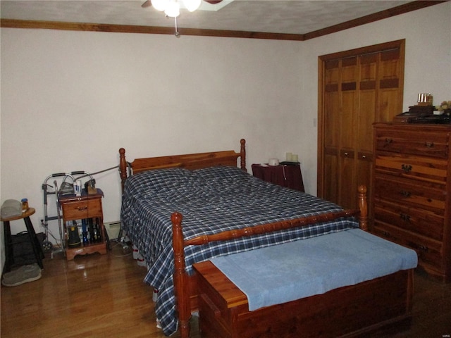 bedroom with a baseboard radiator, a closet, ceiling fan, crown molding, and dark hardwood / wood-style floors