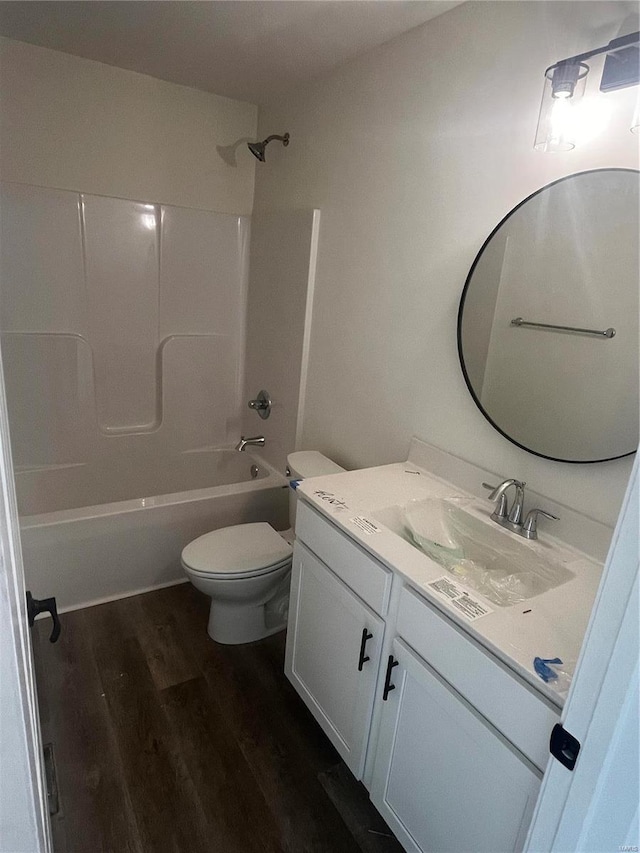 full bathroom featuring toilet, tub / shower combination, wood-type flooring, and vanity