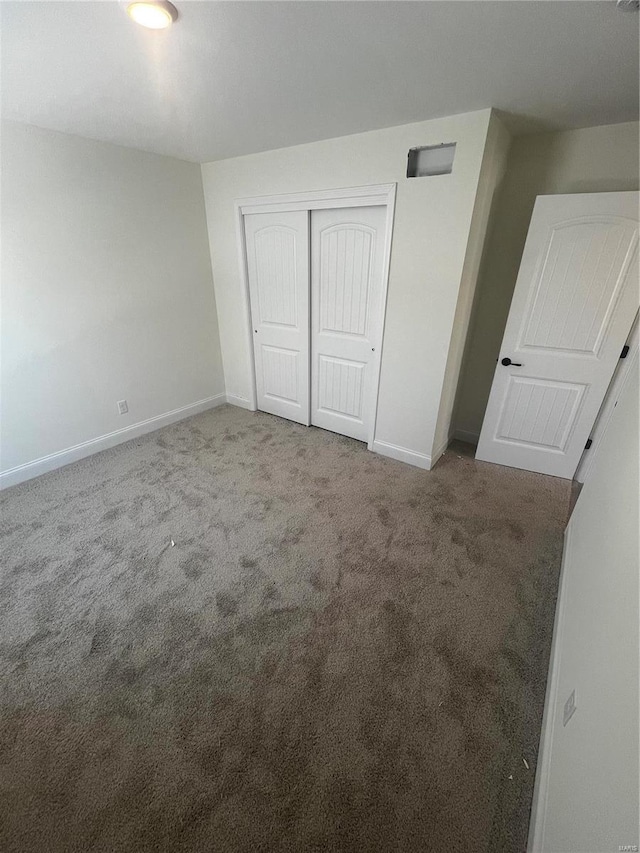 unfurnished bedroom with a closet and carpet floors