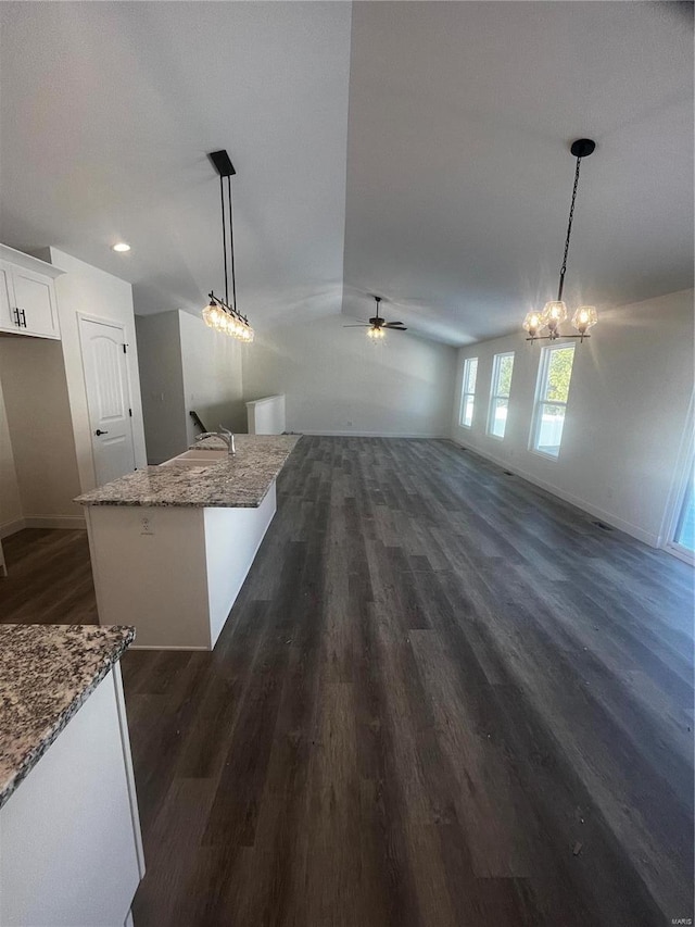 interior space with ceiling fan with notable chandelier and dark hardwood / wood-style flooring