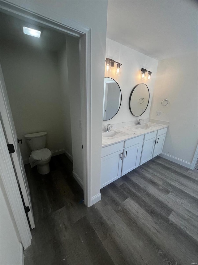 bathroom with toilet, vanity, and hardwood / wood-style flooring