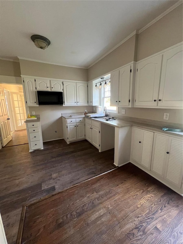 kitchen featuring ornamental molding, sink, dark wood-type flooring, and white cabinetry