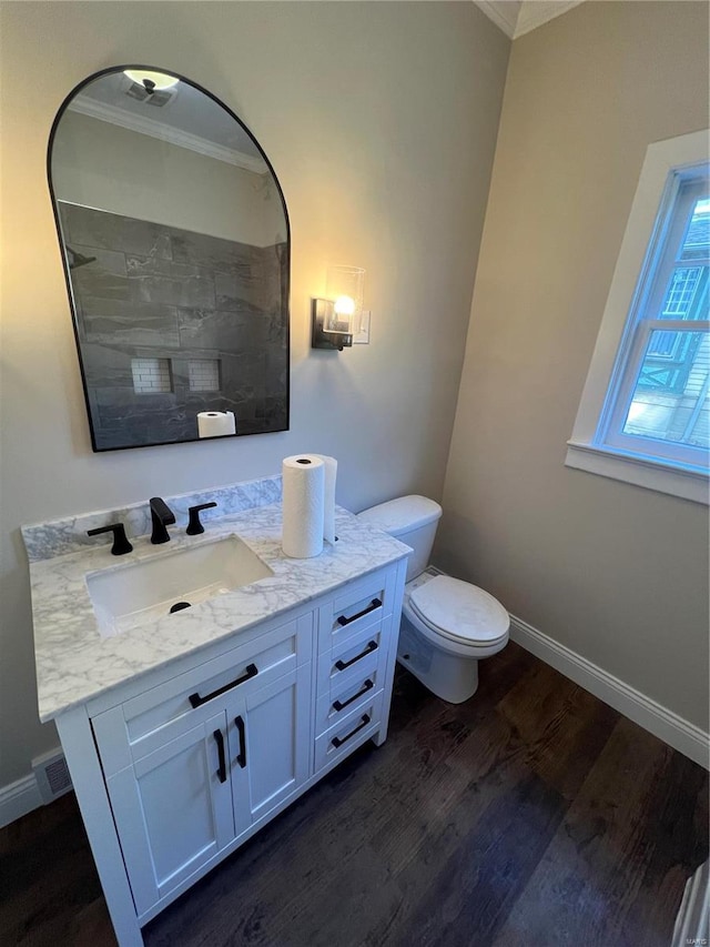 bathroom with ornamental molding, toilet, vanity, and wood-type flooring