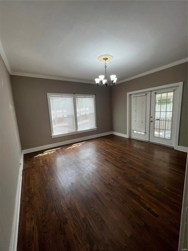 spare room with a notable chandelier, crown molding, and dark hardwood / wood-style floors