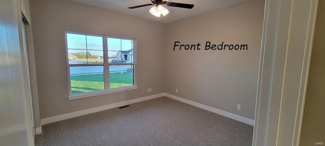 carpeted spare room with ceiling fan