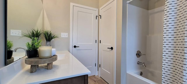 bathroom featuring hardwood / wood-style floors, vanity, and tub / shower combination