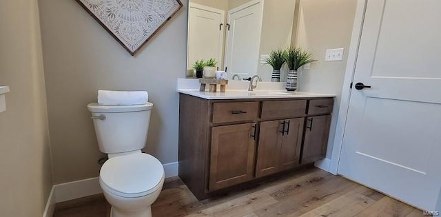 bathroom with hardwood / wood-style floors, vanity, and toilet