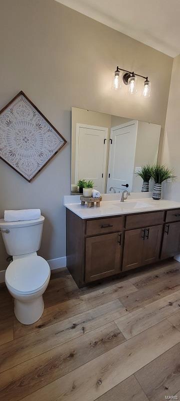 bathroom featuring wood-type flooring, vanity, and toilet