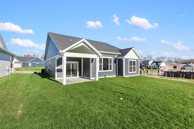 rear view of house featuring central AC unit, a yard, and a patio