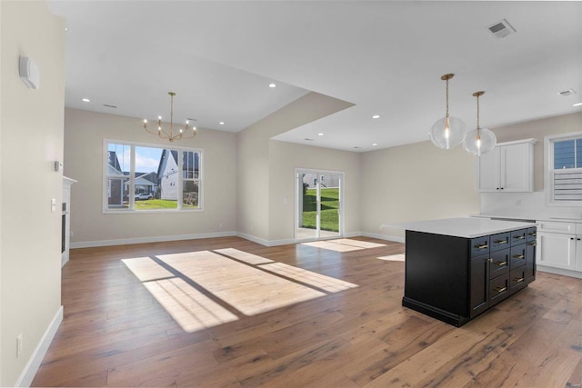 kitchen with a wealth of natural light, a center island, white cabinets, and light wood-type flooring