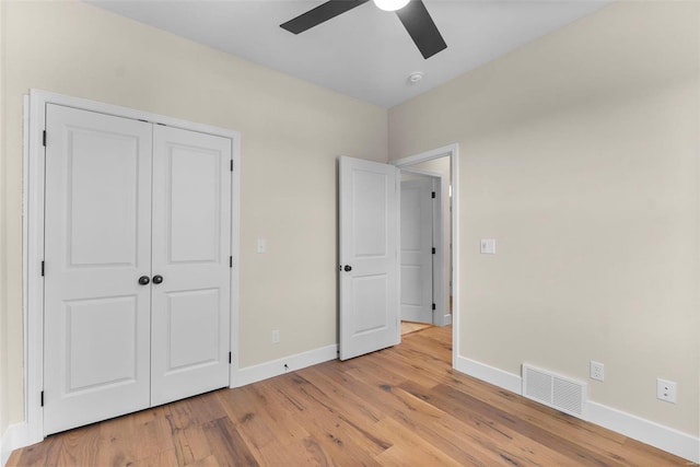 unfurnished bedroom with a closet, light hardwood / wood-style flooring, and ceiling fan