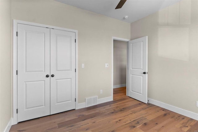 unfurnished bedroom featuring wood-type flooring, a closet, and ceiling fan