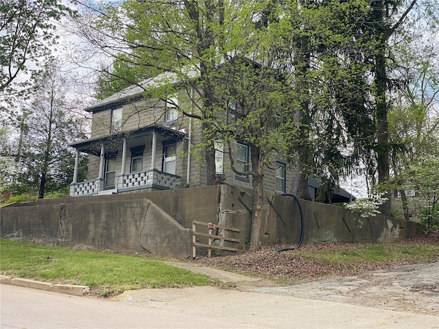 view of side of home featuring covered porch