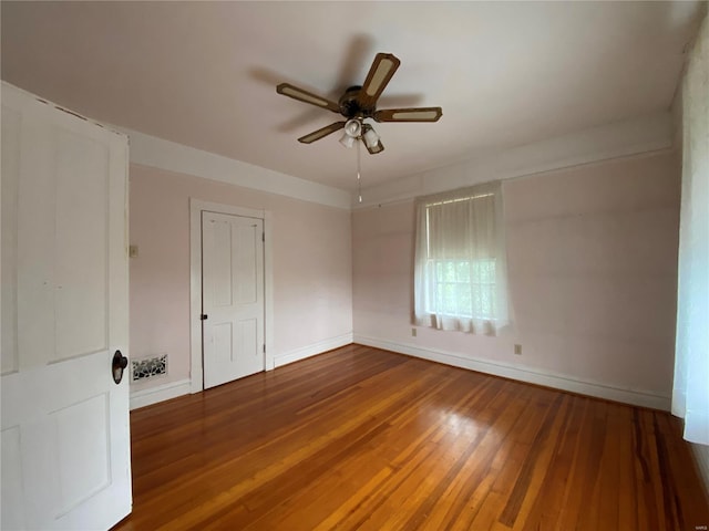 spare room with dark hardwood / wood-style floors and ceiling fan