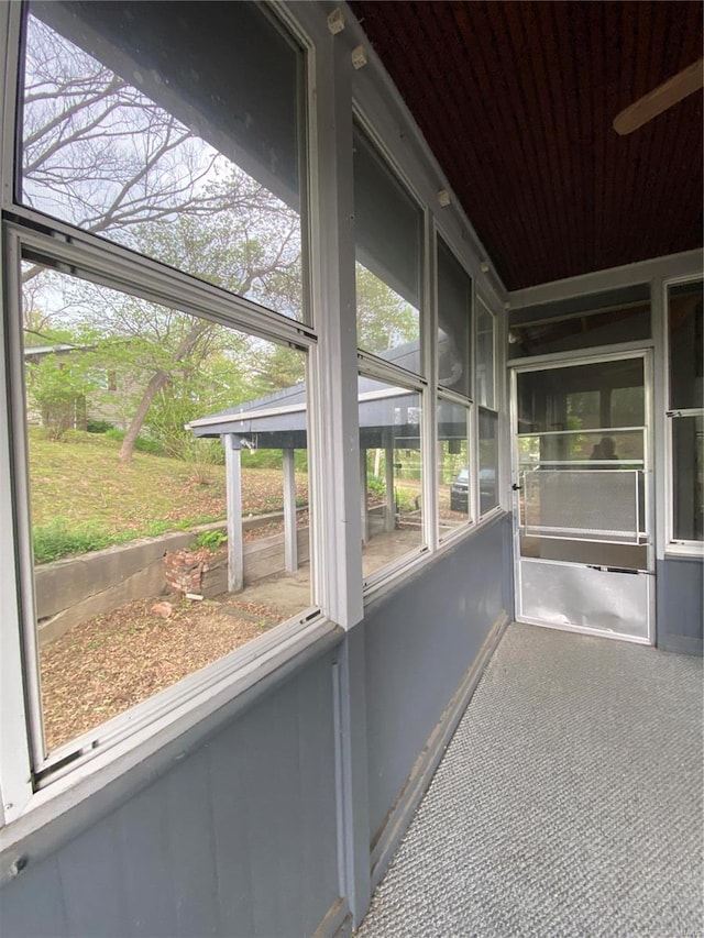 unfurnished sunroom with ceiling fan