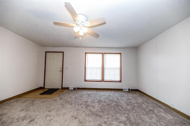 unfurnished room featuring ceiling fan, carpet floors, and a textured ceiling