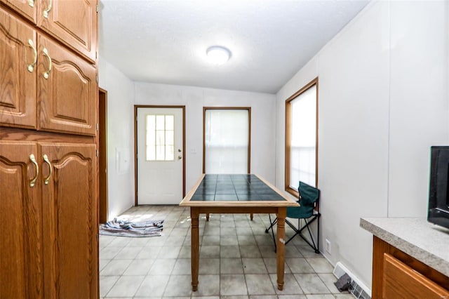 dining area featuring lofted ceiling and light tile flooring