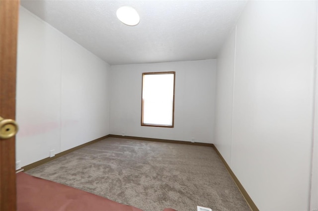 carpeted spare room with a textured ceiling