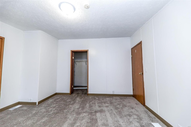 spare room featuring carpet floors and a textured ceiling