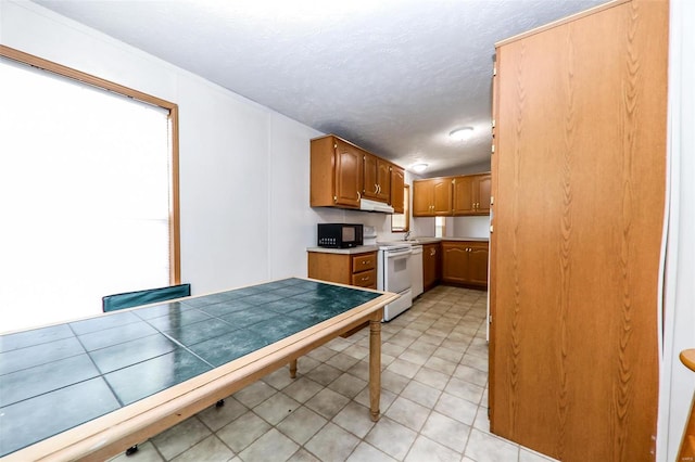 kitchen featuring a textured ceiling, white electric range oven, and light tile floors