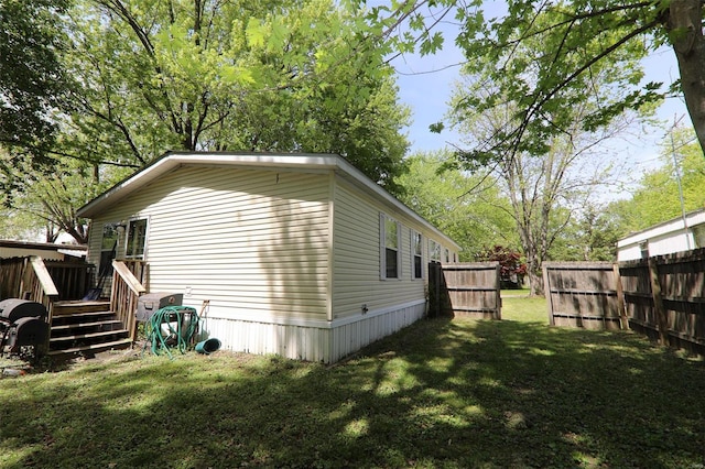 view of home's exterior with a wooden deck and a lawn