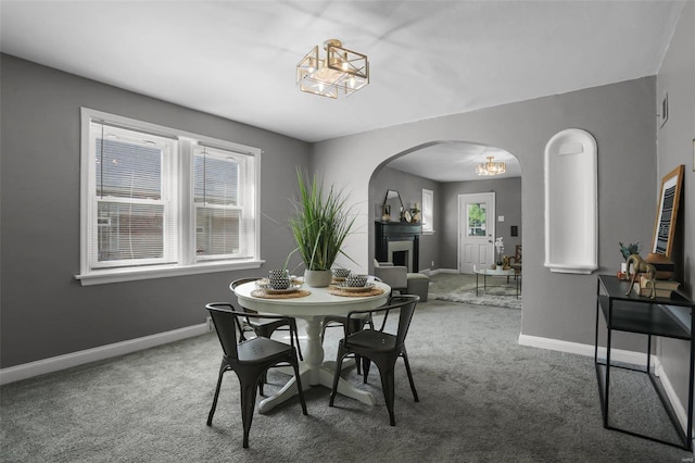 dining space featuring carpet, a chandelier, and a wealth of natural light