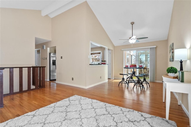 interior space featuring ceiling fan, light hardwood / wood-style flooring, and high vaulted ceiling