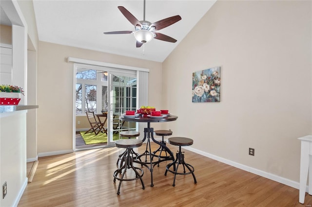 dining space featuring ceiling fan, lofted ceiling, and light wood-type flooring