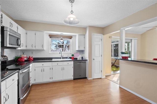 kitchen with white cabinets, sink, a healthy amount of sunlight, and stainless steel appliances