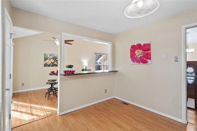 interior space with ceiling fan, a textured ceiling, and hardwood / wood-style floors