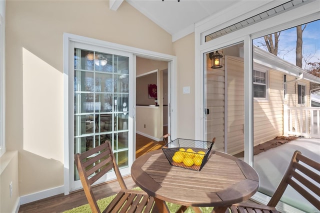 sunroom / solarium featuring lofted ceiling with beams