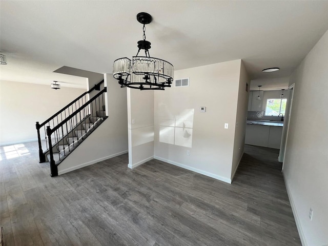 unfurnished dining area with a notable chandelier and dark hardwood / wood-style floors