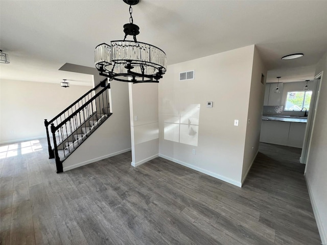 staircase featuring sink, a chandelier, and hardwood / wood-style flooring